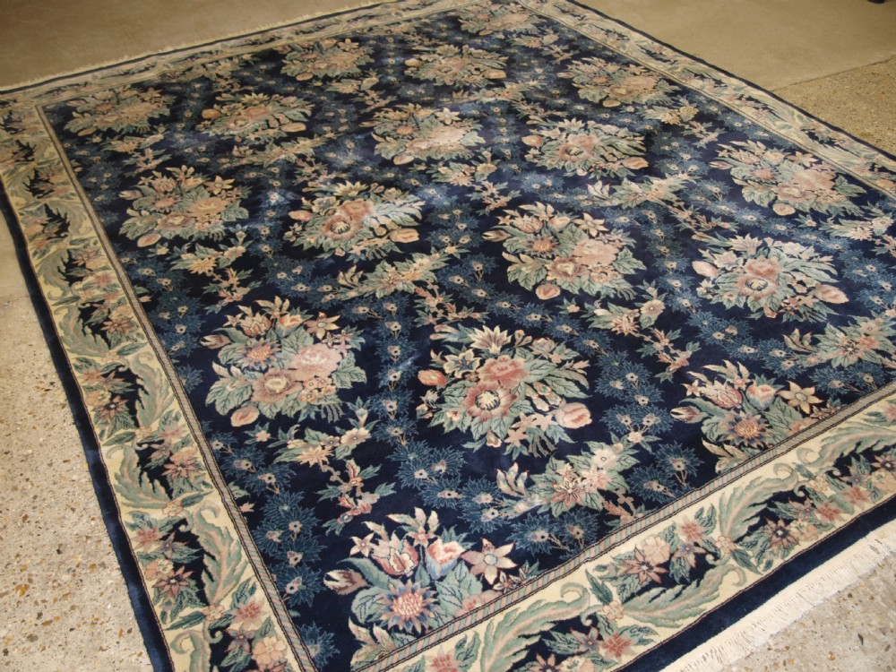 old tabriz carpet with all over floral design soft pastel colours on dark indigo about 30 years old