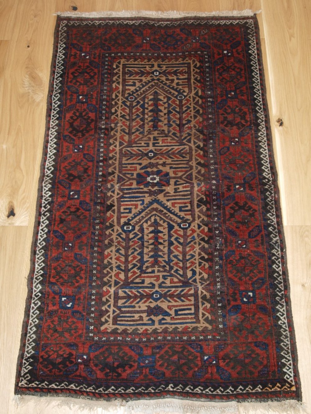 antique baluch rug with camel ground and unusual design old repairs late 19th century
