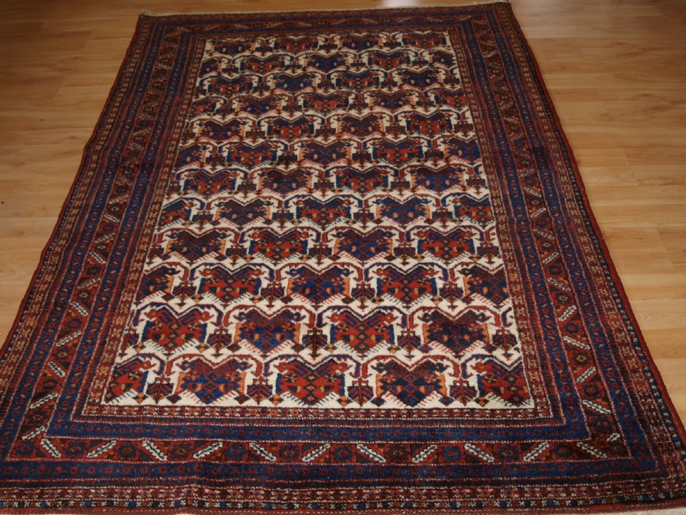 old afshar rug with repeat shield design on an ivory ground circa 1920